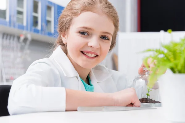 Girl with green plant in lab — Free Stock Photo