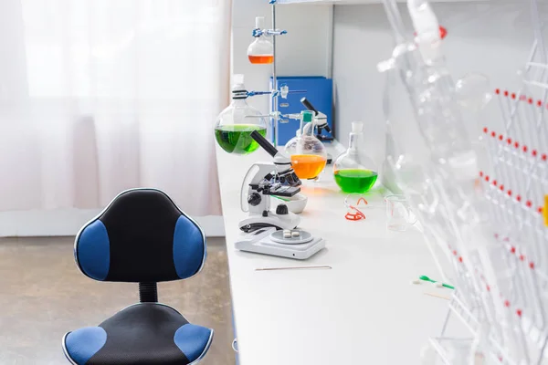 Microscope and reagents in laboratory — Stock Photo, Image