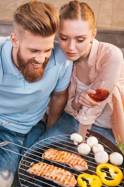 Couple grilling meat and vegetables — Stock Photo, Image