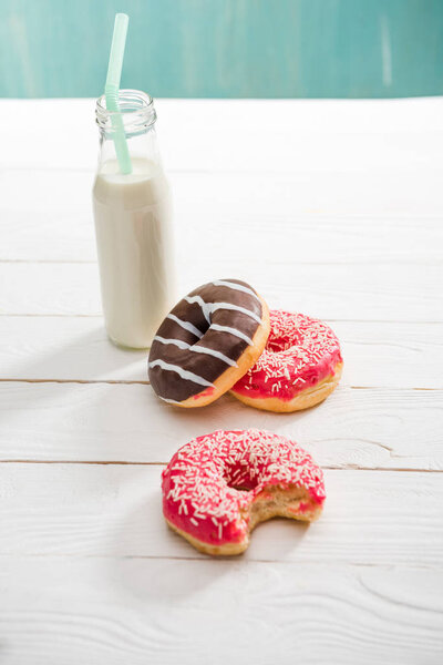 milkshake in glass bottle with sweet donuts 