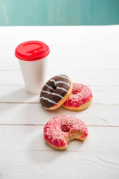 Kaffeetasse und drei Donuts — Stockfoto