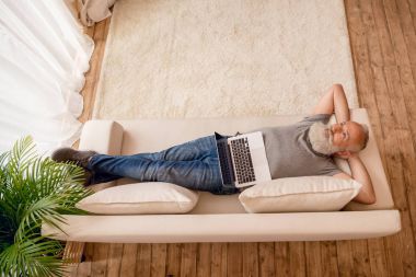 Dizüstü bilgisayar kullanan kıdemli adam.