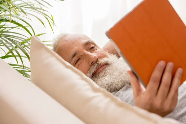 Senior man die digitale tablet gebruikt — Stockfoto