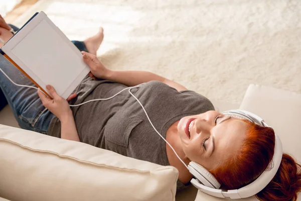 Vrouw die muziek luistert in een hoofdtelefoon — Stockfoto