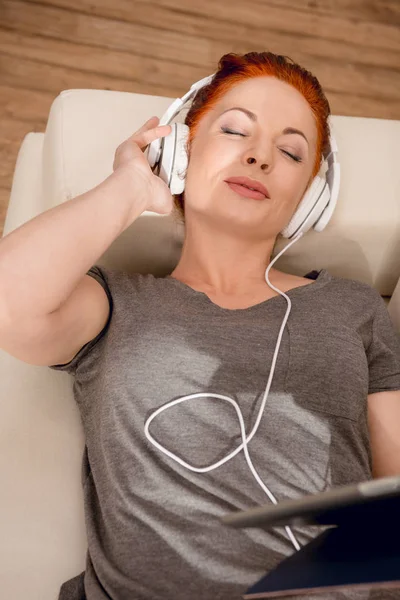 Kobieta słuchająca muzyki w słuchawkach — Darmowe zdjęcie stockowe
