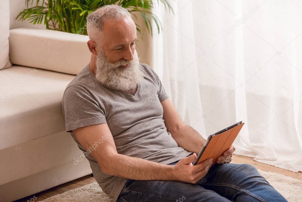 senior man using digital tablet 