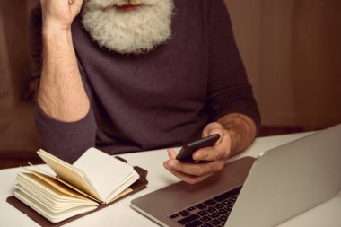 akıllı telefon kullanan gri saçlı adam