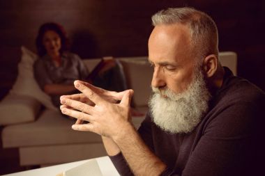 grey haired man sitting in thoughtful pose clipart