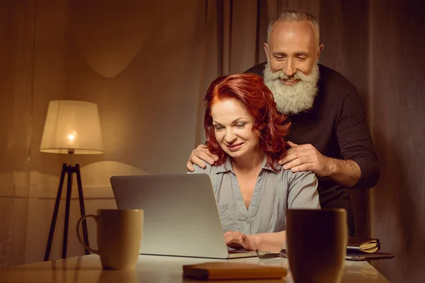 Midden leeftijd paar kijken naar laptop — Stockfoto