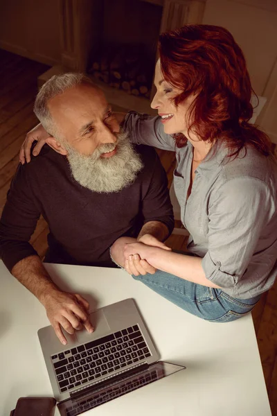 Middle aged couple sitting at table — Stock Photo, Image