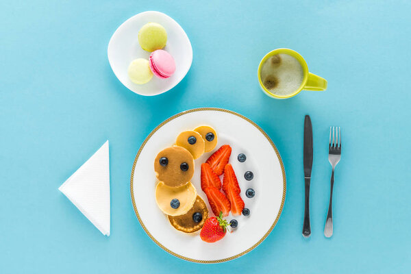 pancakes with berries on plate with macarons