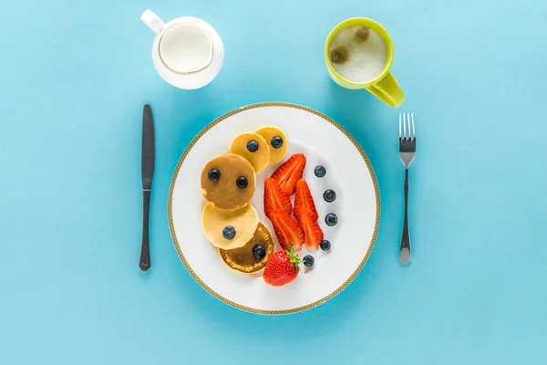 Pancakes with berries on plate with coffee — Stock Photo, Image