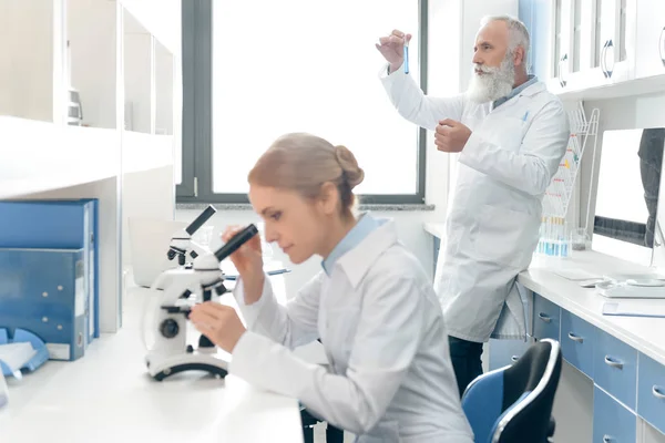 Cientistas em casacos brancos em laboratório — Fotografia de Stock