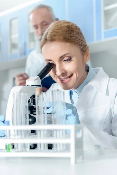 Químico trabajando con microscopio — Foto de Stock