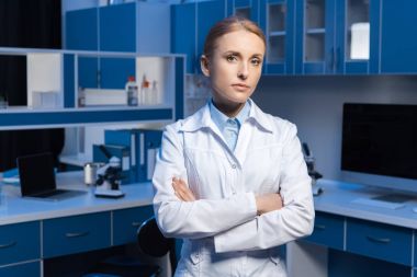 scientist in lab coat with arms crossed