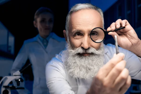 Scientist with magnifying glass — Stock Photo, Image