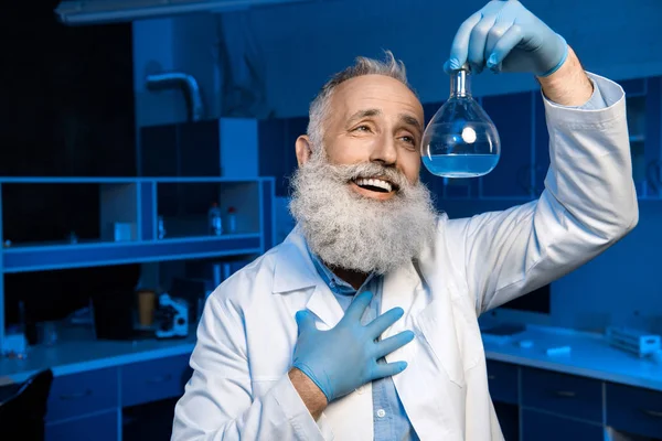 Cientista de cabelos grisalhos segurando frasco — Fotografia de Stock