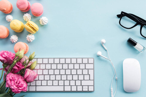 keyboard, macarons and flowers on tabletop