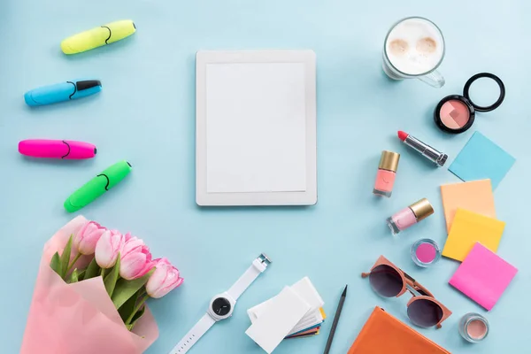 Tableta, varios accesorios y flores en la mesa — Foto de Stock