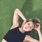 Zamyślony kobieta, leżąc na trawie