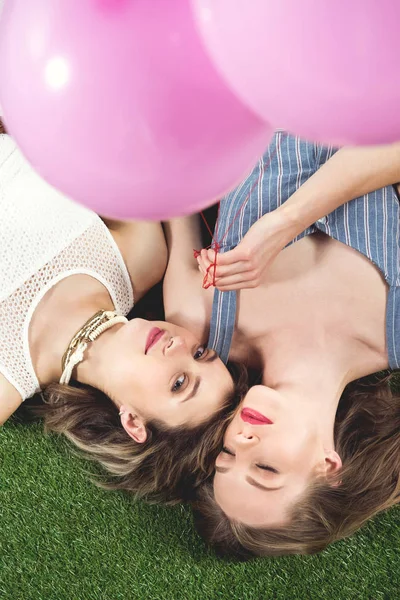 Young lesbian couple lying on grass — Stock Photo, Image