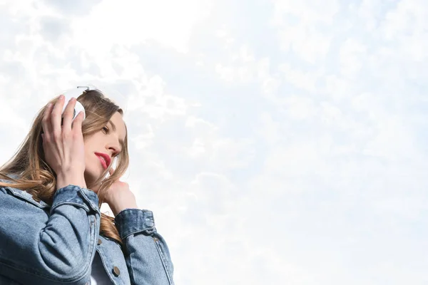 Chica pensativa escuchando música en los auriculares — Foto de Stock