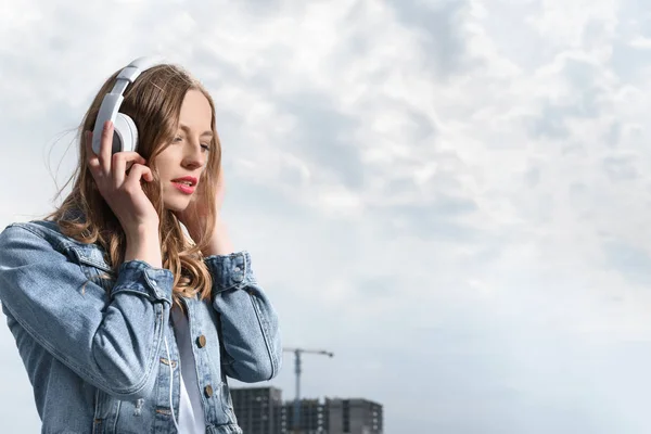 Vrouw die muziek luistert in een hoofdtelefoon — Stockfoto