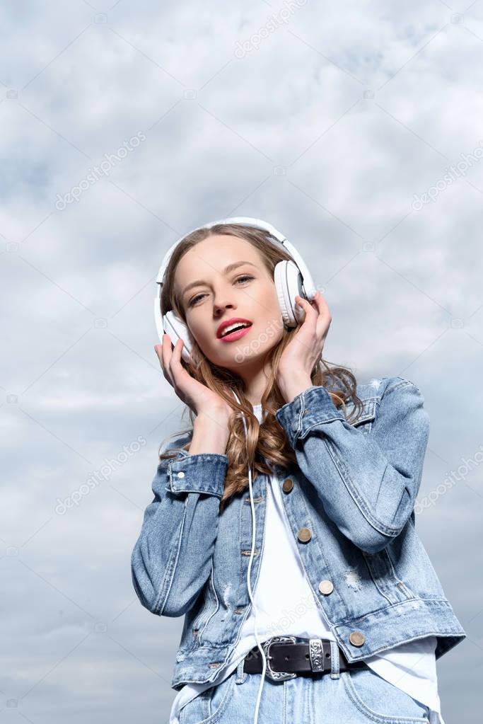 young woman listening music in headphones