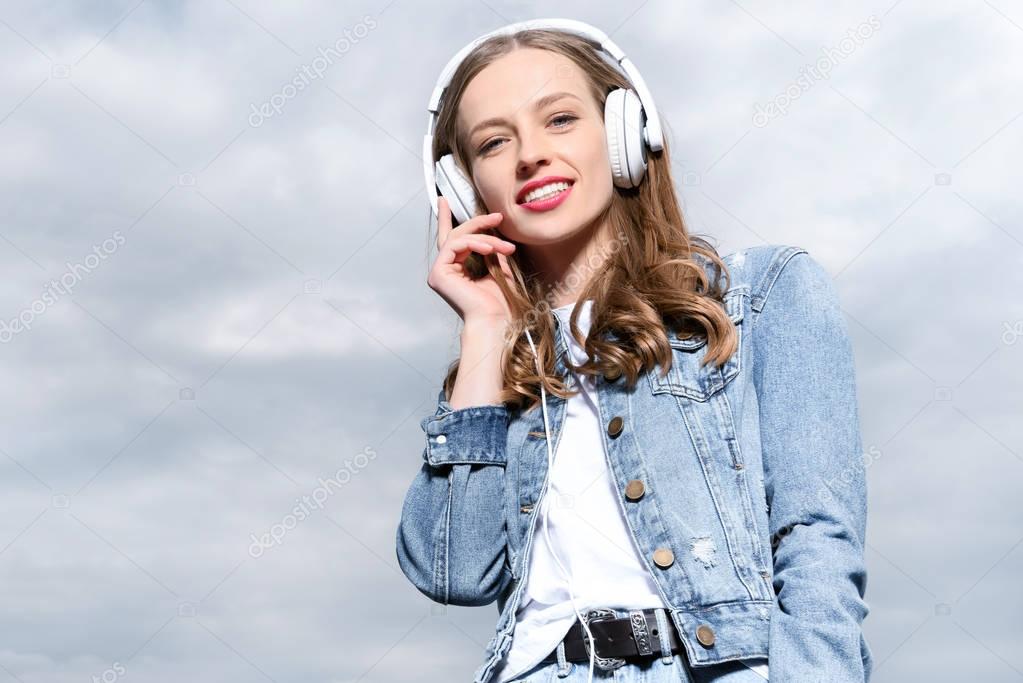 young woman listening music in headphones
