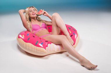 woman eating watermelon on float ring clipart