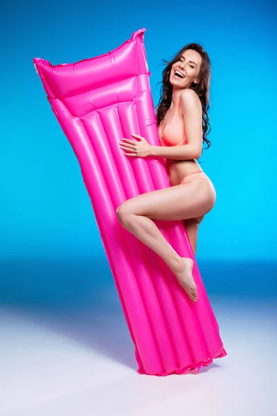 Mujer joven con colchón de natación — Foto de Stock
