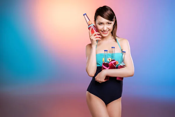 Dziewczyna w stroju kąpielowym, trzymając butelki — Darmowe zdjęcie stockowe