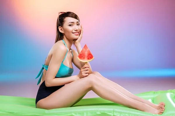 Mädchen im Badeanzug isst Wassermelone — Stockfoto