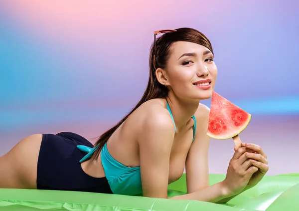 Mädchen im Badeanzug isst Wassermelone — Stockfoto