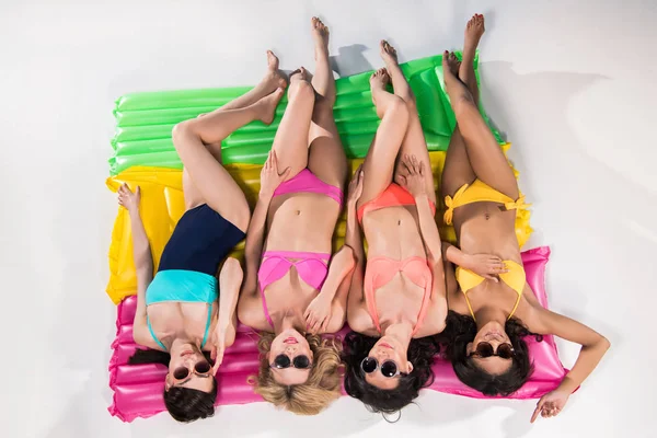 Girls in swimsuits sunbathing on swimming mattresses — Stock Photo, Image