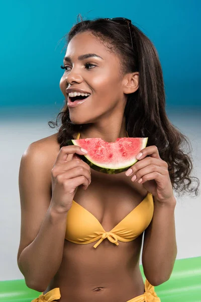 Mladá žena v plavkách jíst meloun — Stock fotografie