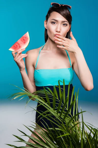 Asian woman in swimsuit eating watermelon — Stock Photo, Image