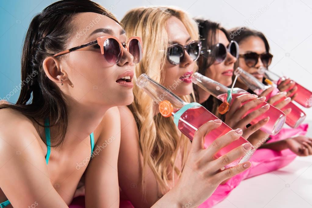 girls drinking cocktails while sunbathing