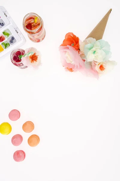 Flowers with macaroons and beverages — Stock Photo, Image