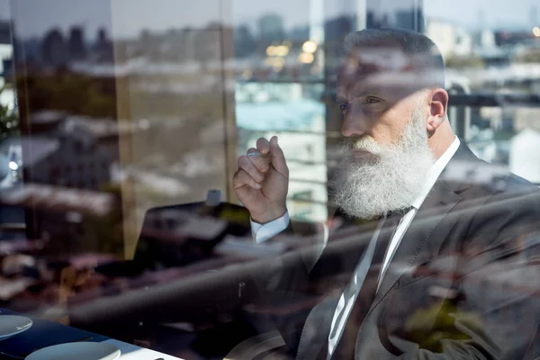 Concentrated mature bearded businessman — Stock Photo, Image