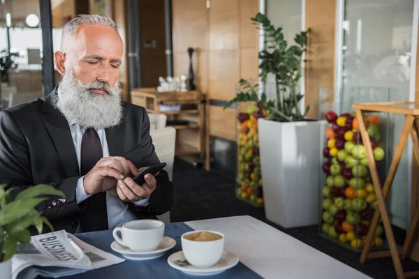 Zakenman smartphone met restaurant — Stockfoto