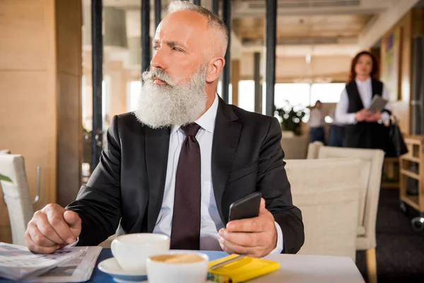 Restoranda Smartphone kullanarak iş adamı