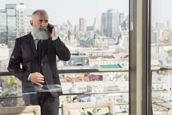 Businessman talking by phone on balcony — Free Stock Photo