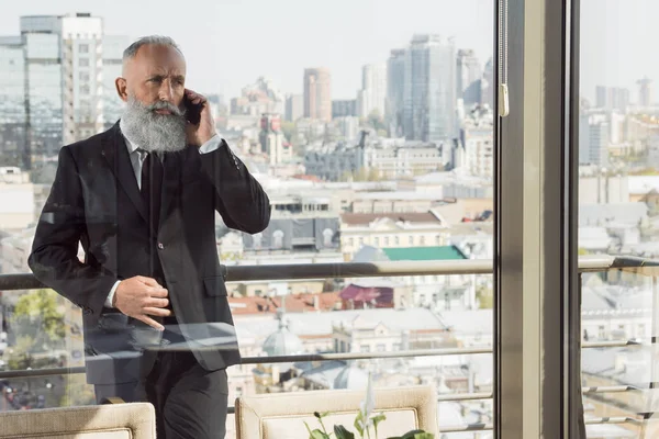 Hombre de negocios hablando por teléfono en el balcón — Foto de stock gratis