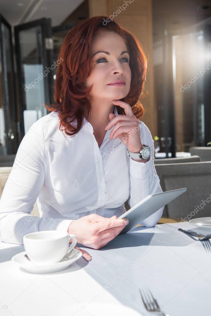 businesswoman with tablet in restaurant