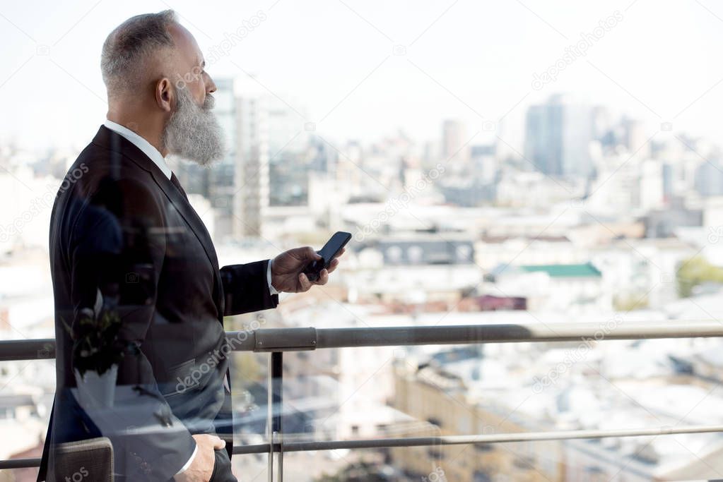 businessman using smartphone on balcony