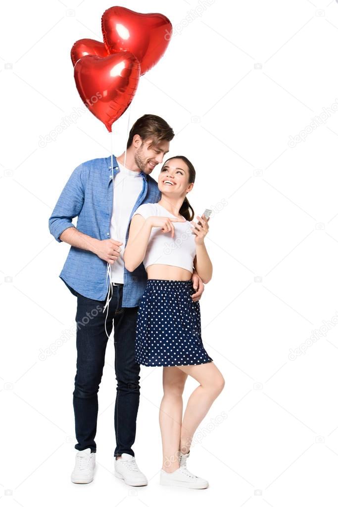 couple with smartphone and balloons 