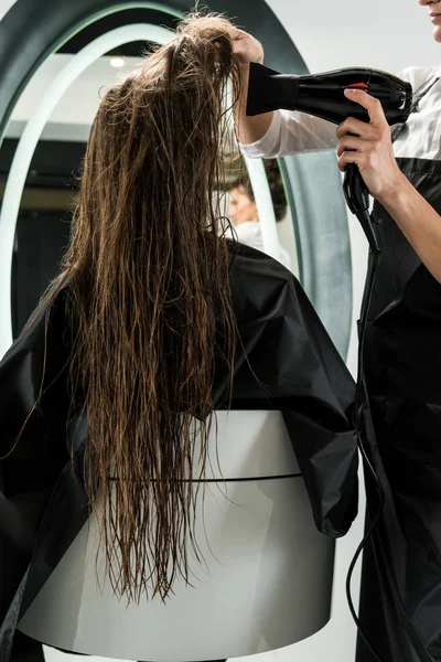 Hairdresser drying hair of woman — Stock Photo, Image