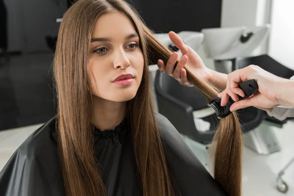 Hairdresser brushing hair of woman — Stock Photo, Image