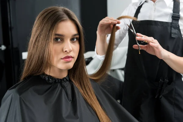 Стилист стрижет волосы женщины — стоковое фото